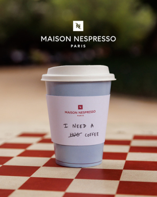 Gobelet Nespresso avec slogans imprimés exposés en vitrine du Café Nespresso
