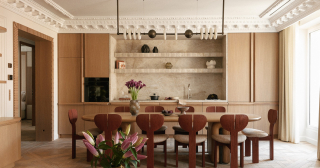 Salle à manger avec table en bois et cuisine ouverte habillée de marbre et de chêne clair