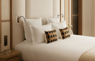 Chambre élégante avec tête de lit capitonnée, coussins graphiques et palette beige minimaliste


.