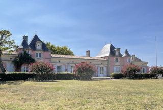 Façade pastel du Château Loudenne, surnommé « Château Rose », avec jardins et vue sur l’estuaire