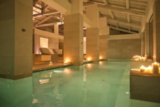 Le hammam oriental et les bassins chauffés du Relais Histó, baignés de lumière douce et de bougies, offrent une atmosphère apaisante et luxueuse.