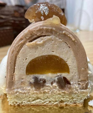 Coupe d’un dessert montrant les différentes couches : mousse de marrons, insert fruité et biscuit fondant.