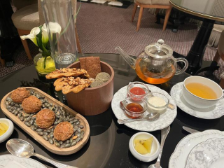 Plateau de choux au sésame et courge, biscuits, condiments et thé aux herbes sur une table de tea time