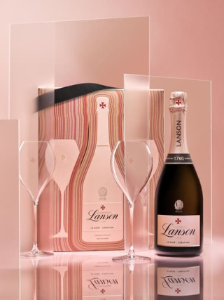 Présentation du coffret limité Lanson Vibrant Edition incluant une bouteille de Rosé Création et deux flûtes, design aux lignes graphiques sur fond rose