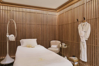 Salle de soin du spa AREV avec murs en lattes de bois.